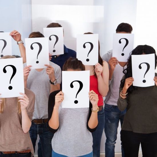 Group of people with question marks covering their faces